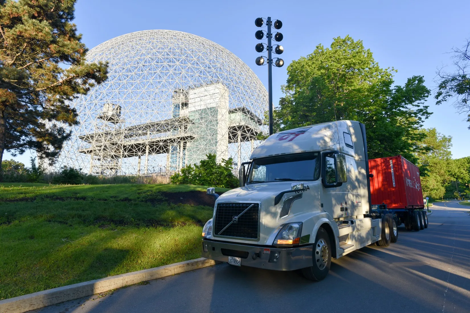Un véhicule tracteur de GT Intermodal transportant un conteneur devant la Biosphère de Montréal